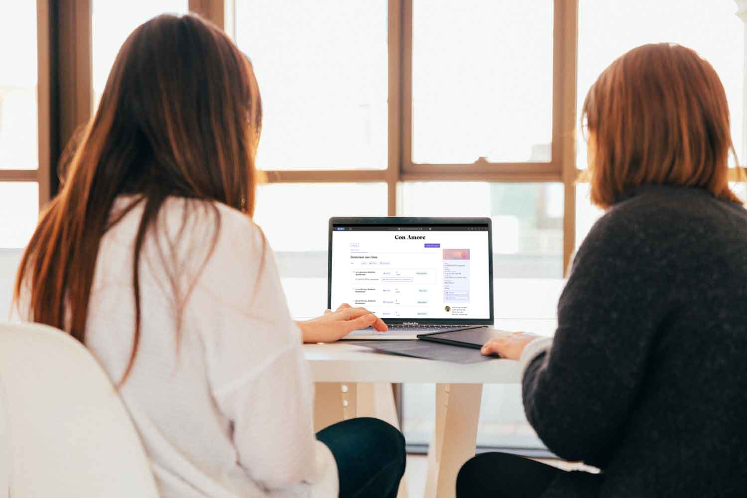 Twee vrouwen op een laptop die een website bekijken