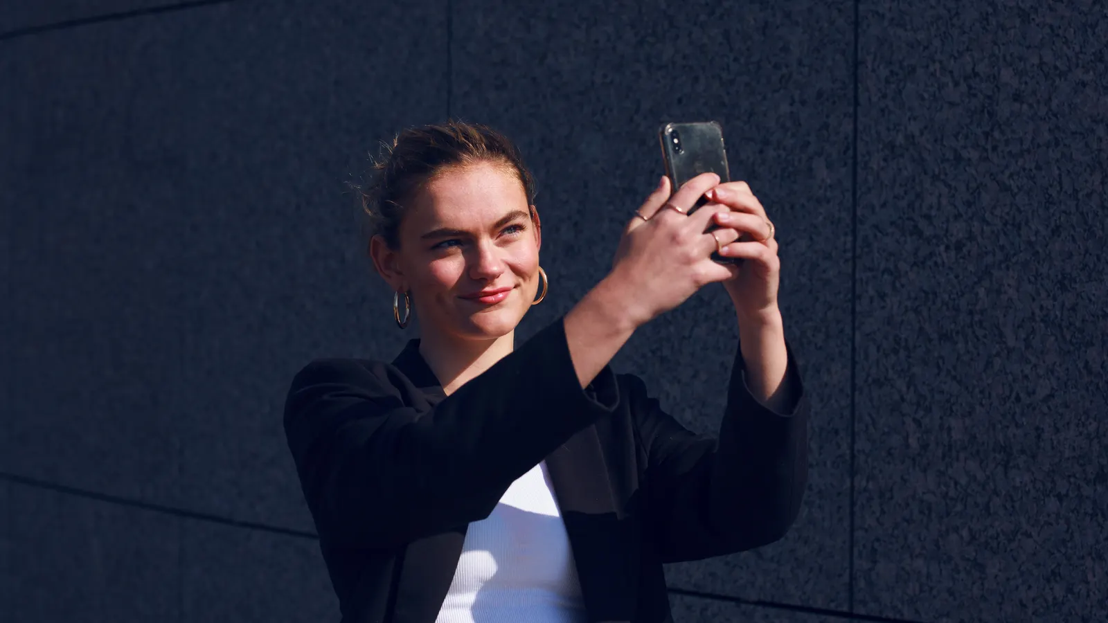 Een professional gebruikt een smartphone tegen een moderne achtergrond